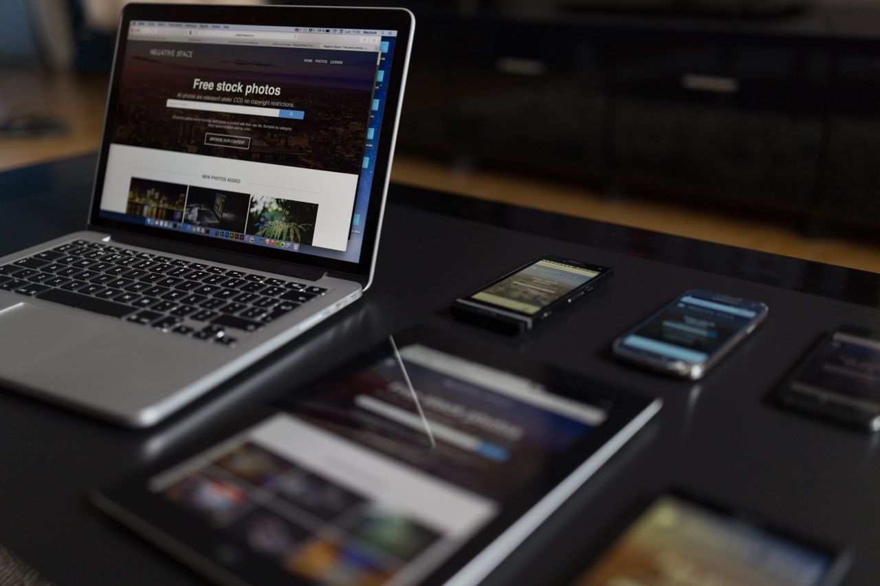 Un espace de travail contemporain mettant en valeur un ordinateur portable, une tablette et des smartphones, idéal pour un usage tech et freelance.